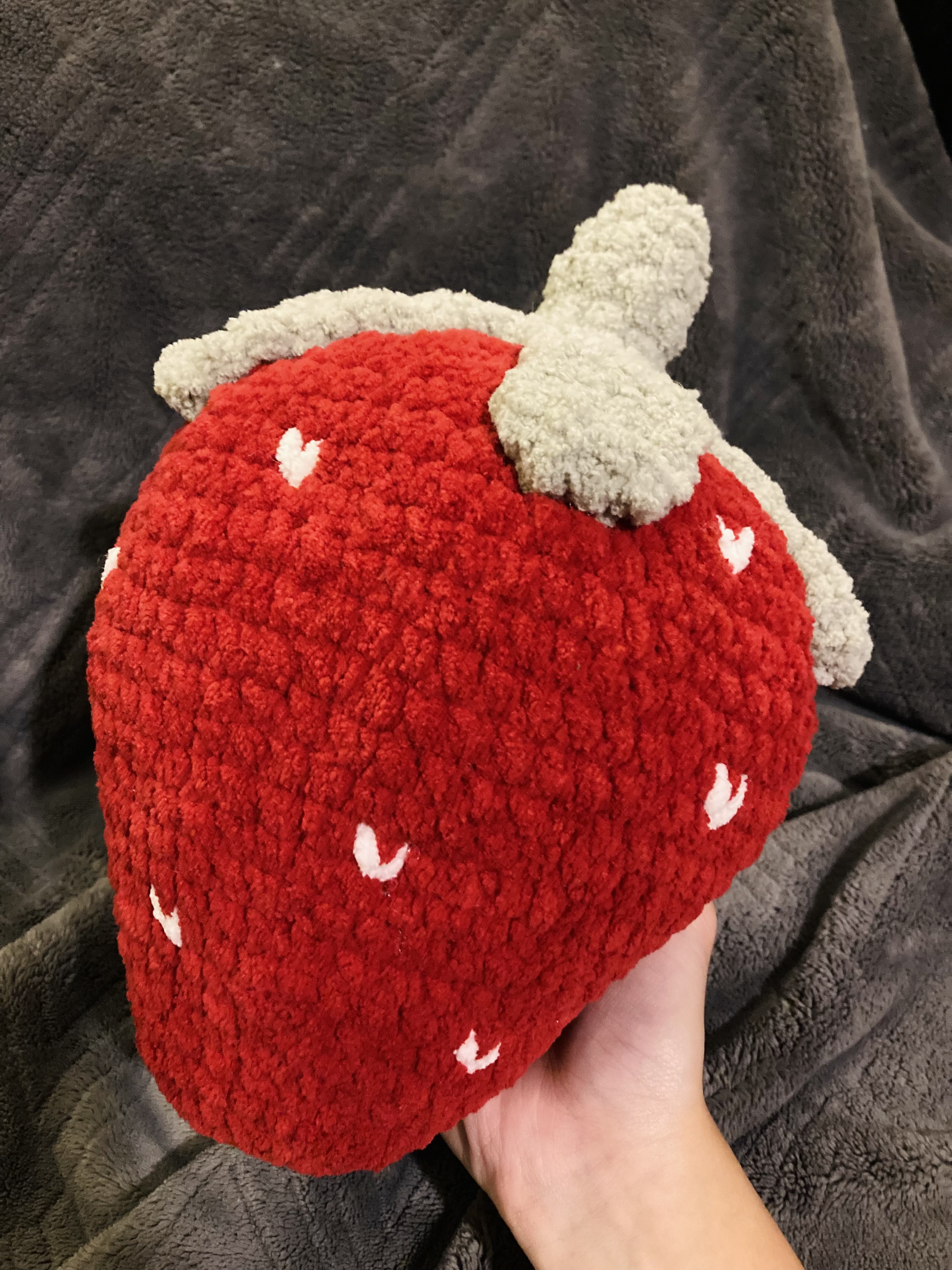 oversized strawberry pillow with textured seeds and leafy top